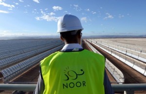 TO GO WITH AFP STORY BY JALAL AL-MAKHFI - A picture taken on October 17, 2015 shows a worker standing in front of solar mirrors at the Noor 1 Concentrated Solar Power (CSP) plant, some 20km (12.5 miles) outside the central Moroccan town of Ouarzazate. On the edge of the Sahara desert, engineers make final checks to a sea of metal mirrors turned towards the sun, preparing for the launch of Morocco's first solar power plant, that has half a million U-shaped mirrors -called "parabolic troughs"- stretch out in 800 rows, slowly following the sun as it moves across the sky.   AFP PHOTO / FADEL SENNA