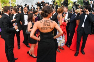 A guest wears an inscription on her back reading "Looking for a part" with her mobile number as she arrives on May 24, 2017 for the screening of the film 'The Beguiled' at the 70th edition of the Cannes Film Festival in Cannes, southern France.  / AFP PHOTO / LOIC VENANCE